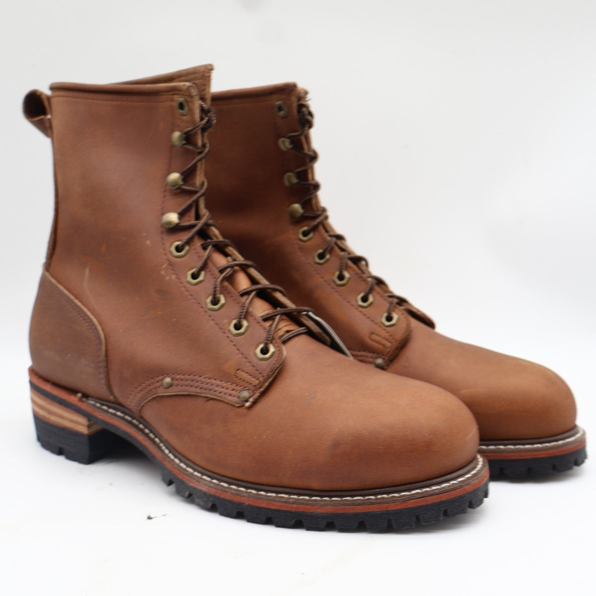 Pair of Carolina brown leather steel toe logger boots with brass eyelets, three-quarter view