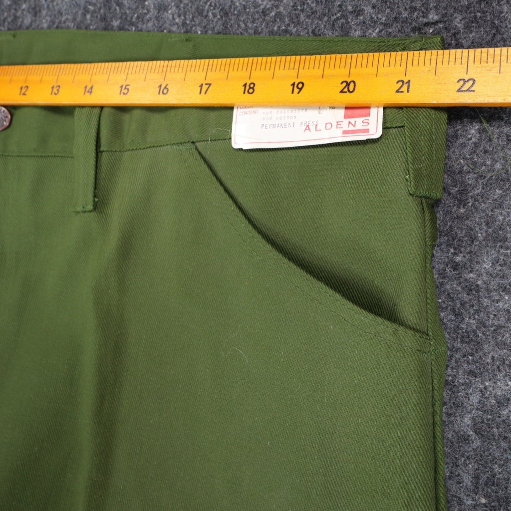 Ruler across the waistband of green Aldens pants