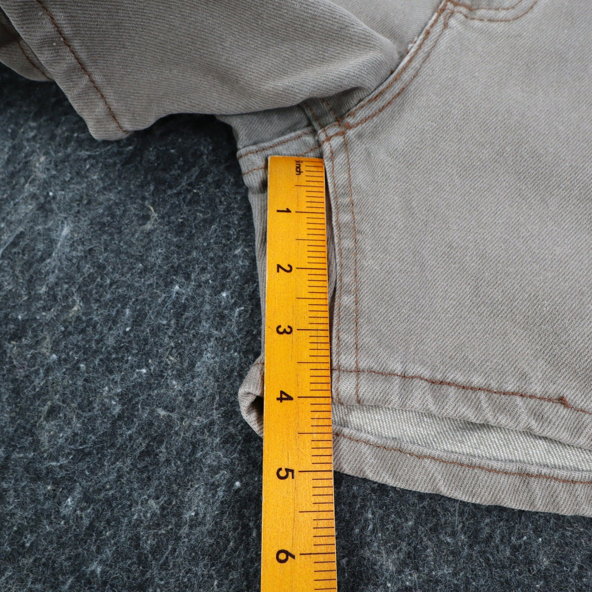Ruler alongside the inner leg of gray Lee denim shorts