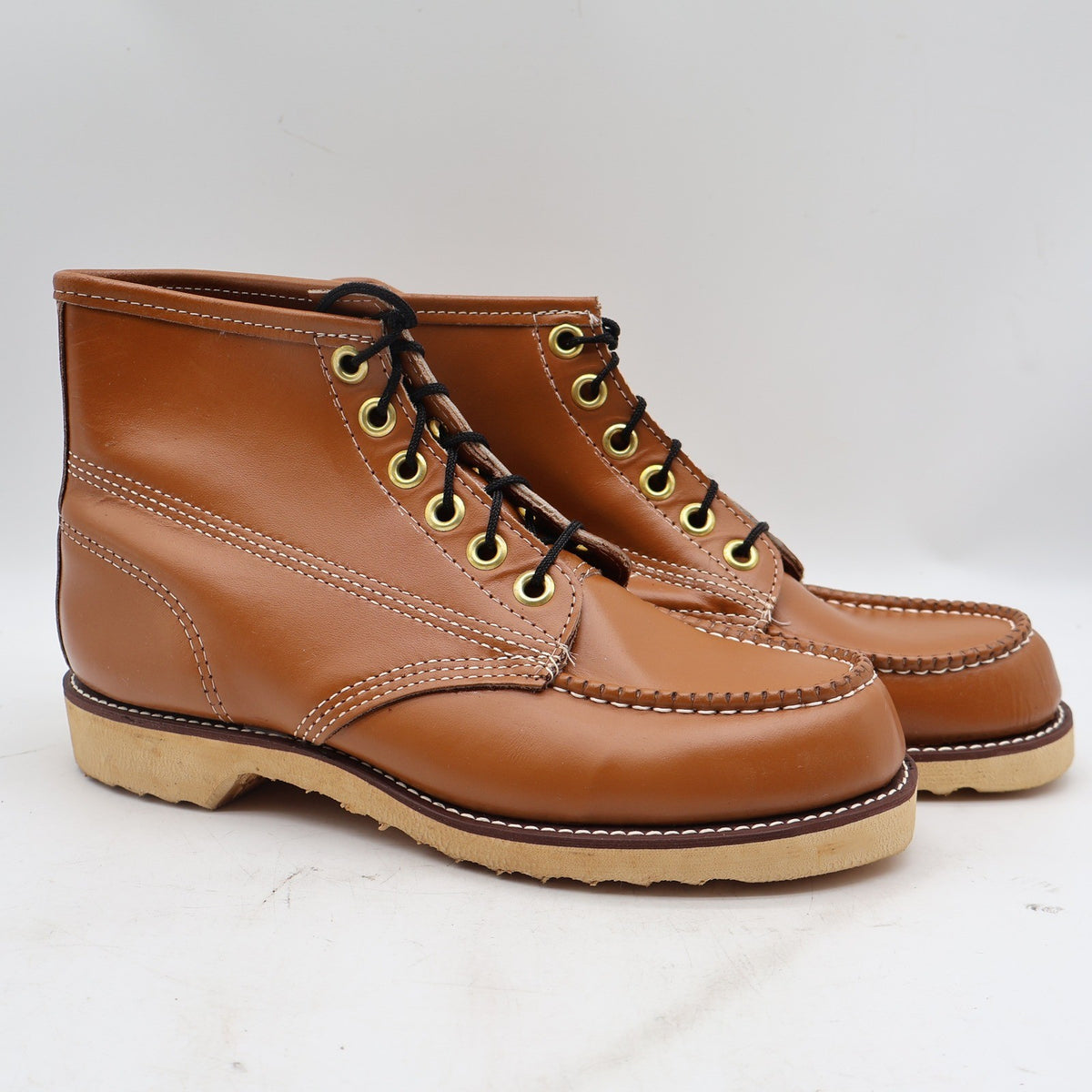Three-quarter view of cognac-brown Cedar Crest moc-toe ankle boots with cream soles with toes pointing right