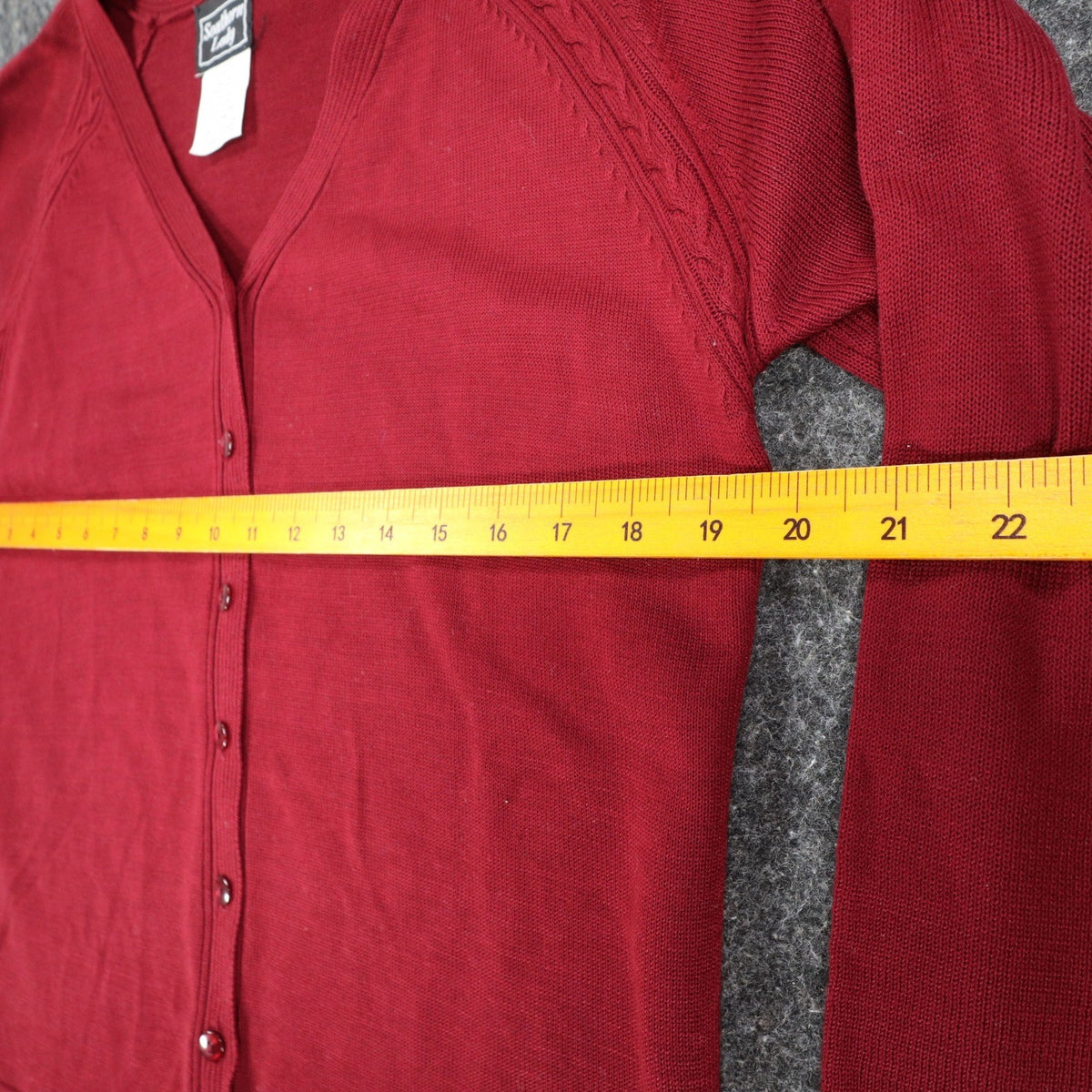 Wine-red Southern Lady button-front cardigan, ruler across chest
