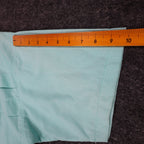 Ruler along the short sleeve of an aqua blue Alexxus short-sleeve shirt