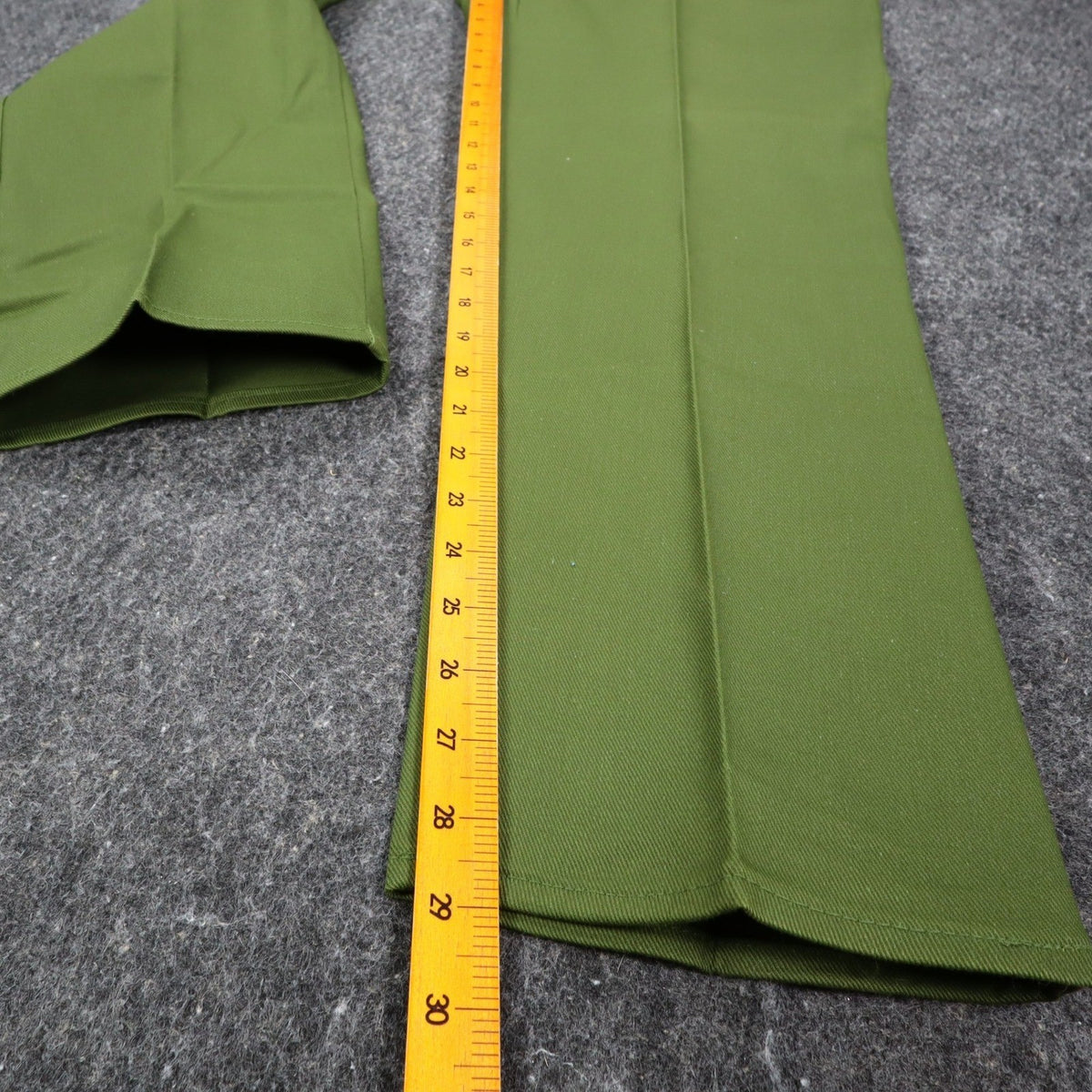 Ruler alongside the inner leg of green Aldens pants