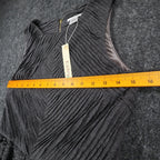 Ruler across the chest of charcoal gray Esley sleeveless dress with textured pleats and a black belt