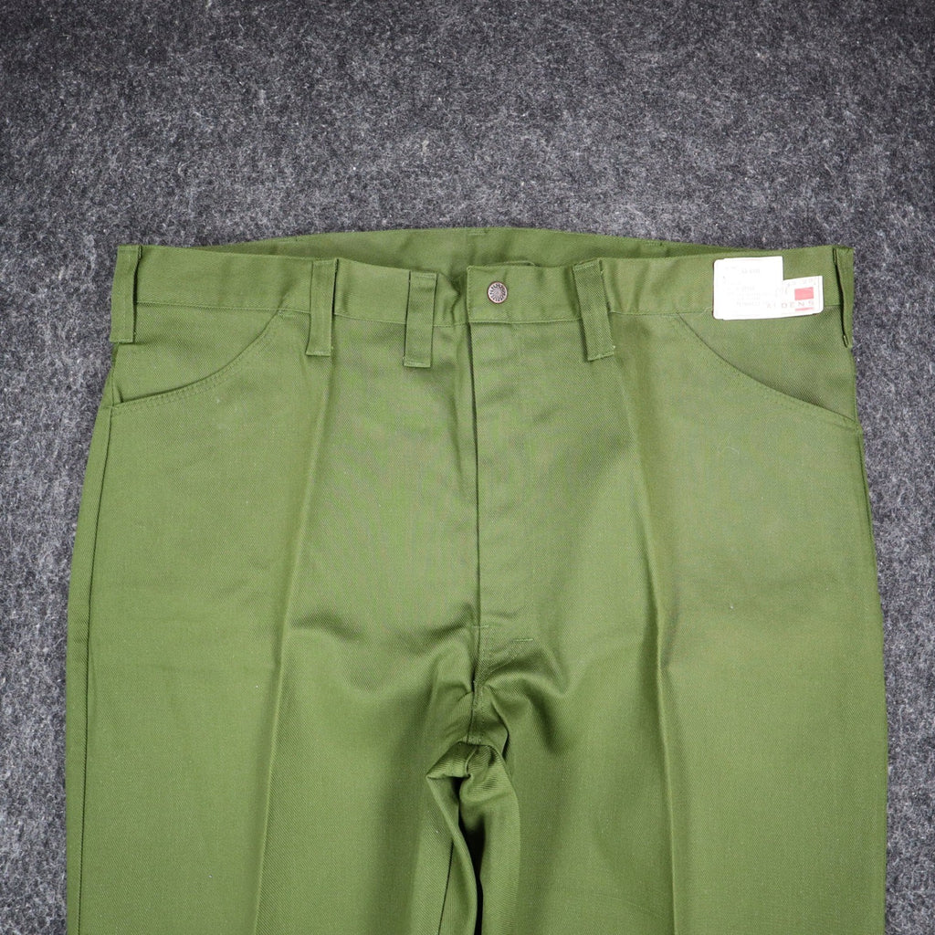 Close-up of the front waist, fly and pockets of green Aldens pants