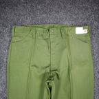Close-up of the front waist, fly and pockets of green Aldens pants