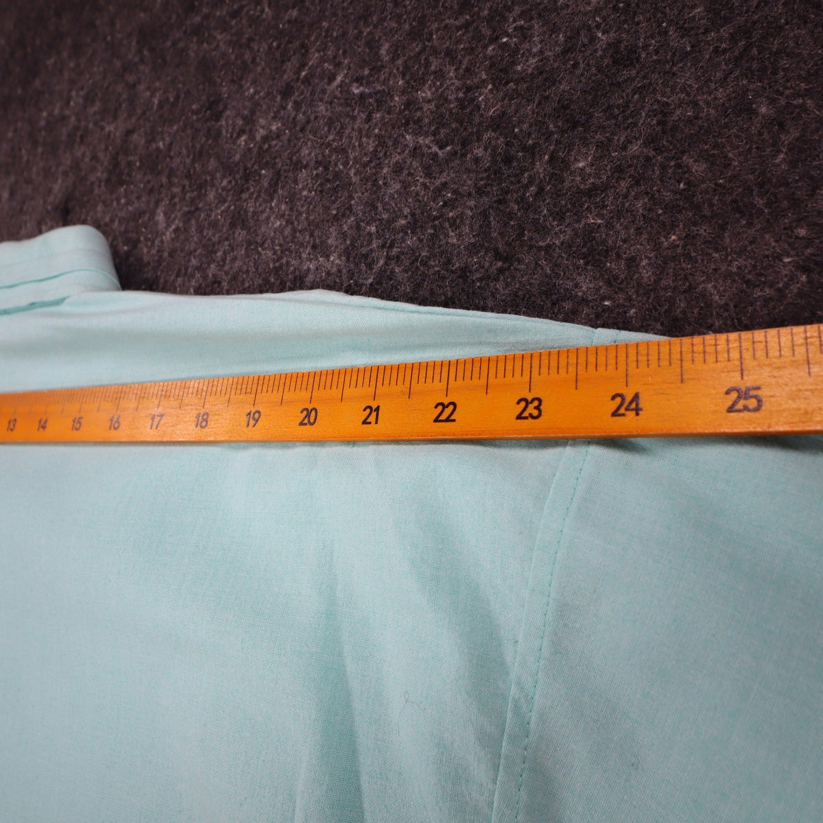 Ruler across the shoulders of aqua blue Alexxus short-sleeve shirt