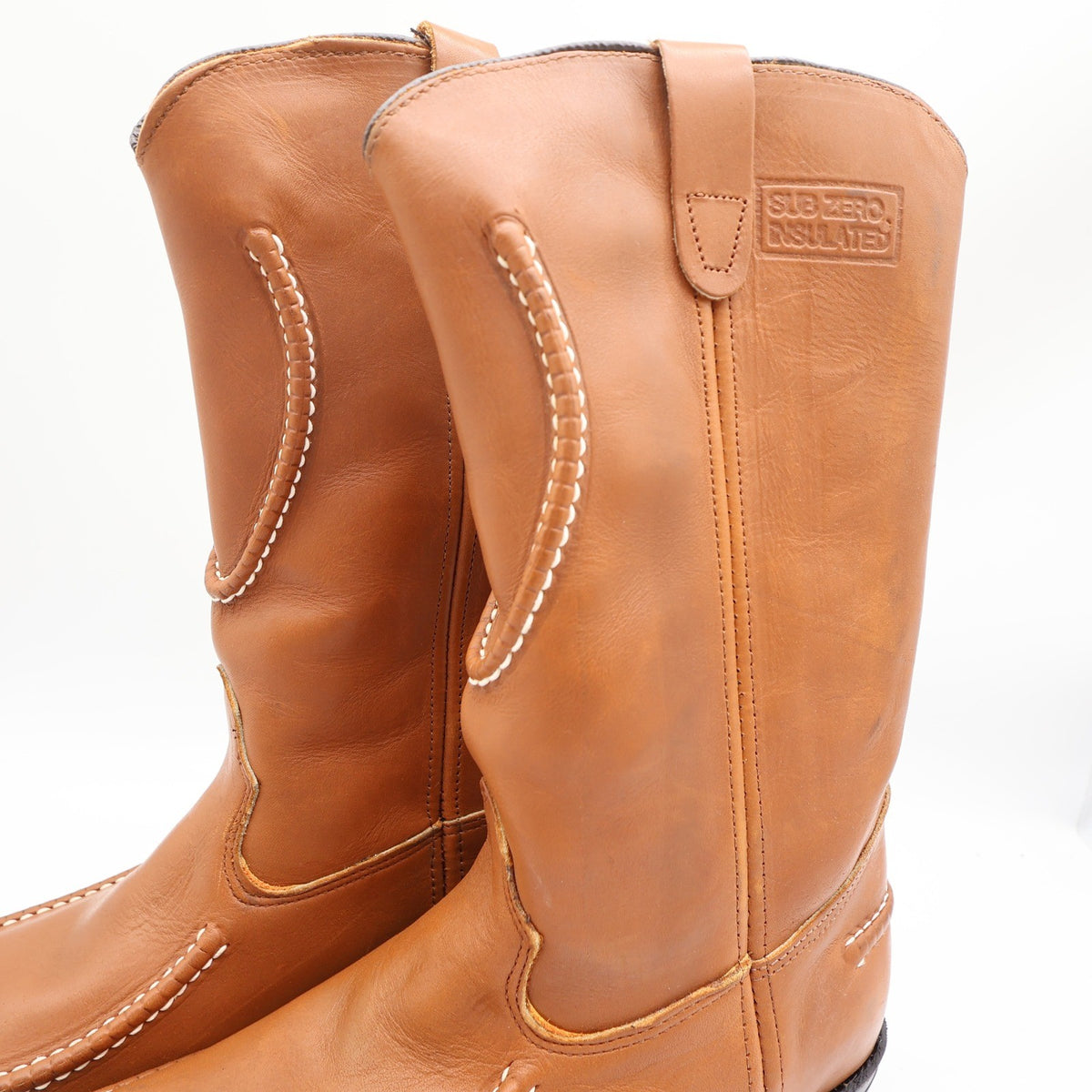 Close-up of pull tabs and cream stitching on brown Double-H boot shafts