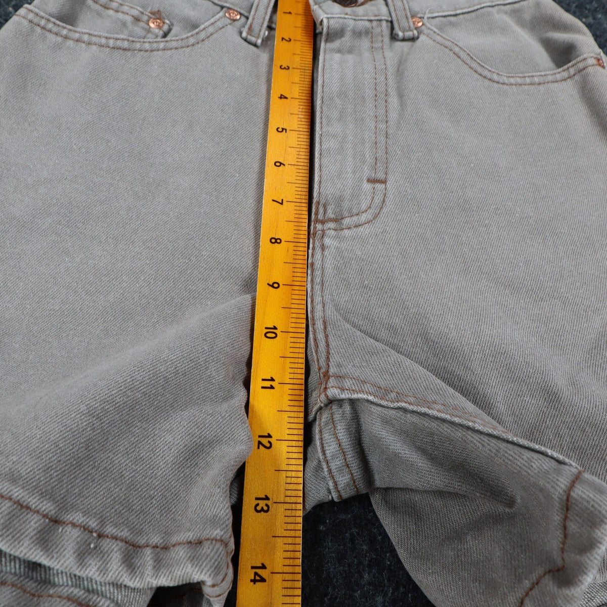 Ruler from the waistband to the crotch of gray Lee denim shorts