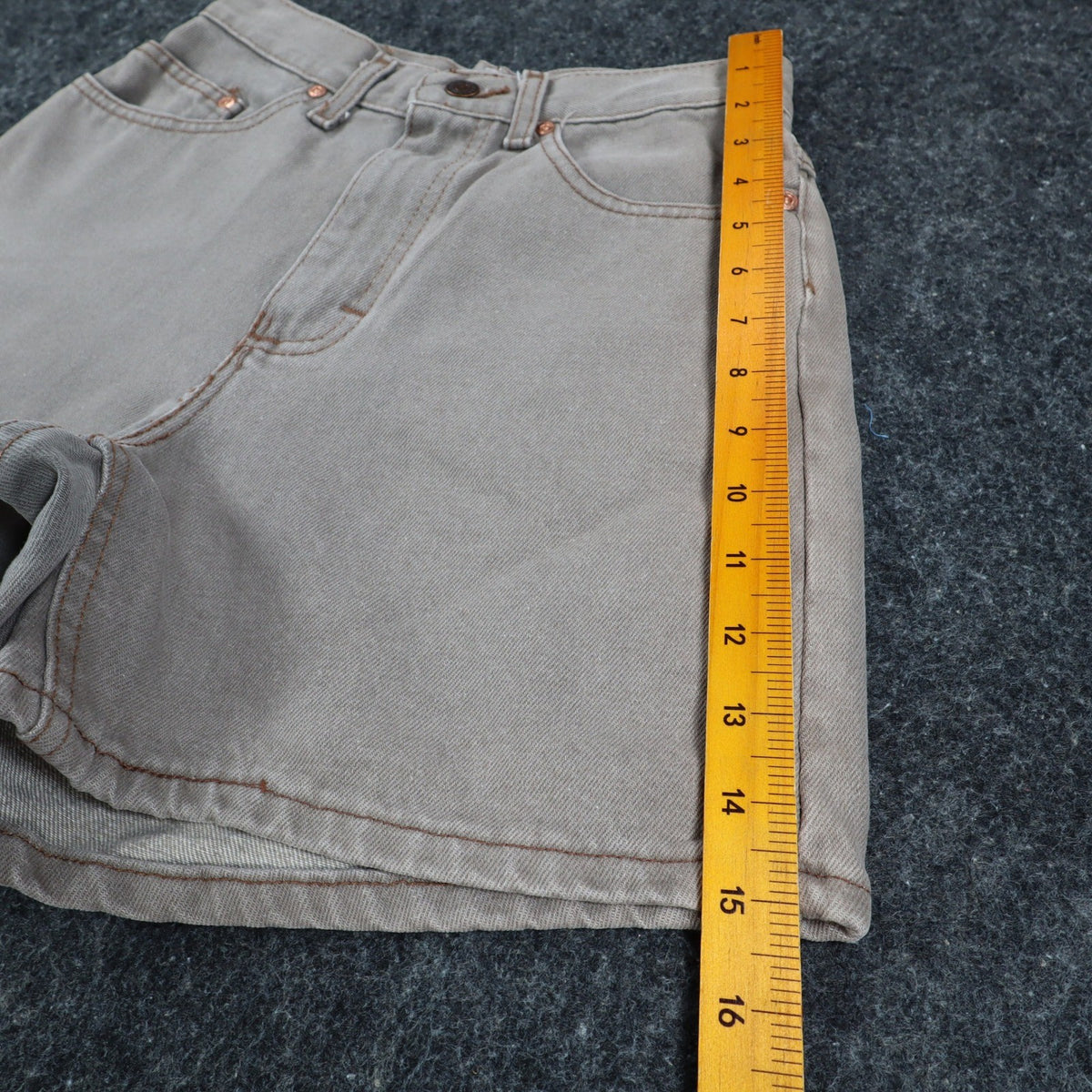Ruler alongside the outer leg of gray Lee denim shorts
