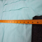 Ruler across the chest of aqua blue Alexxus short-sleeve shirt