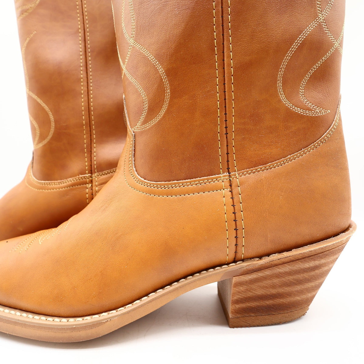 Tan Acme cowboy boots, close-up of side seams and stacked-look heel