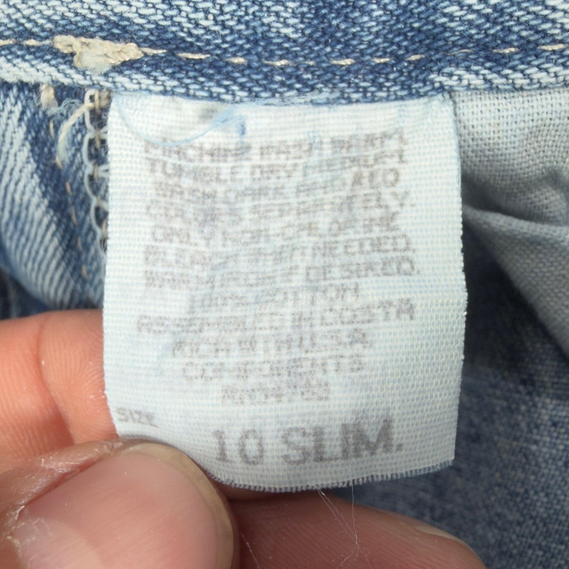Close-up of a faded care, fabric-content and size label
