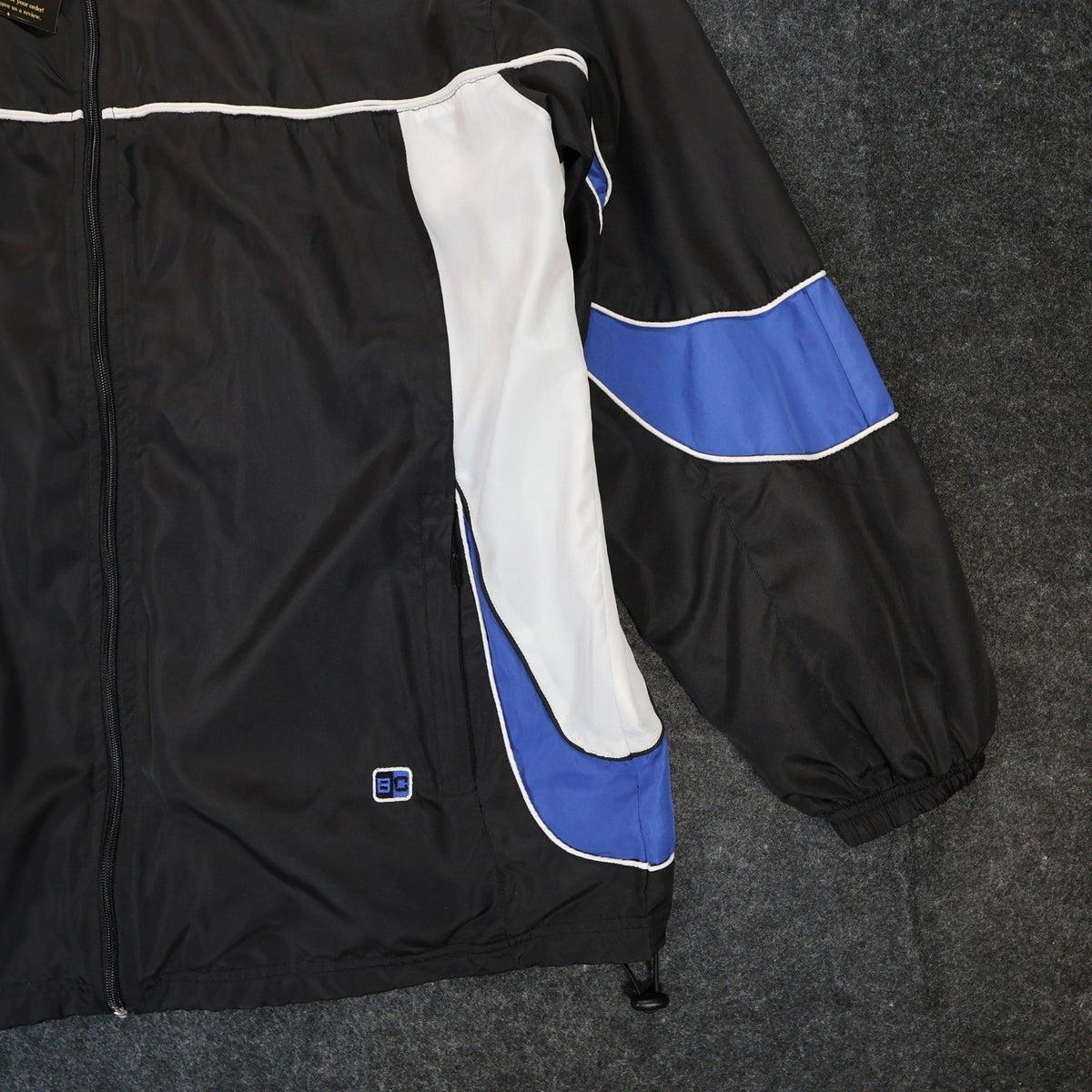 Close-up of the blue sleeve stripe, white side panel and hem logo