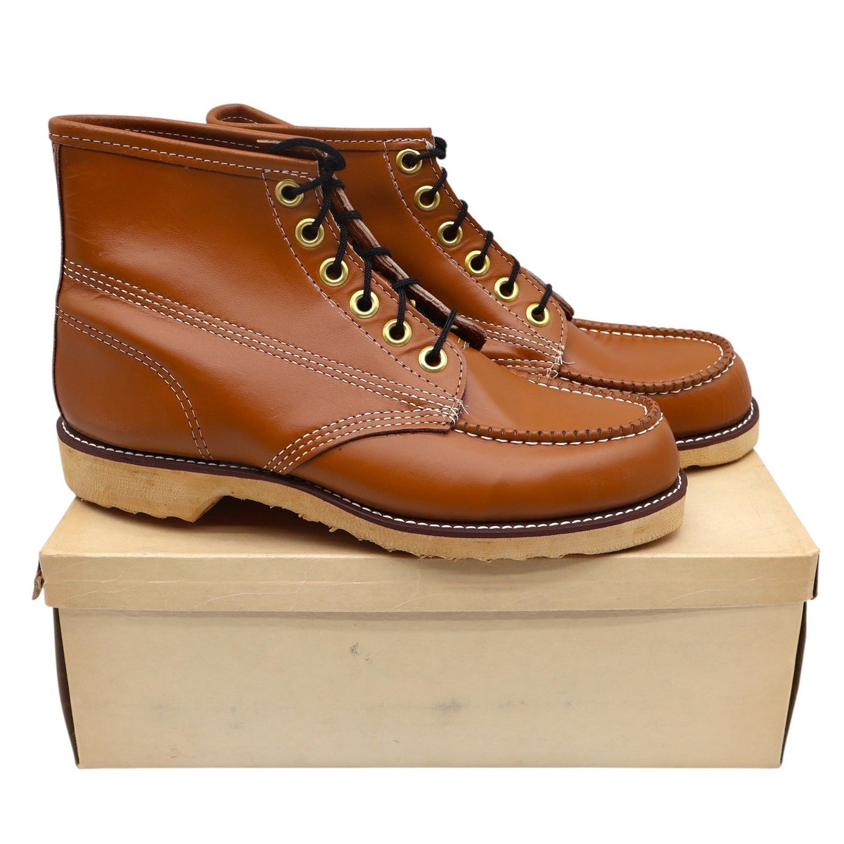Pair of cognac-brown Cedar Crest moc-toe boots displayed on a plain shoebox