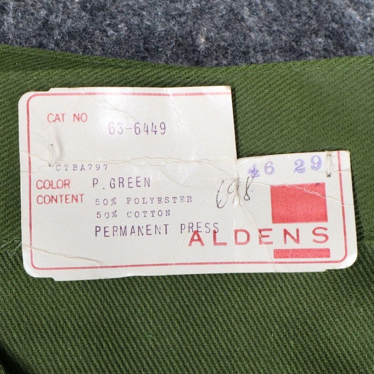 Close-up of the Aldens product label attached to green pants
