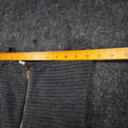Ruler across the shoulders of charcoal gray Esley sleeveless dress with textured pleats and a black belt
