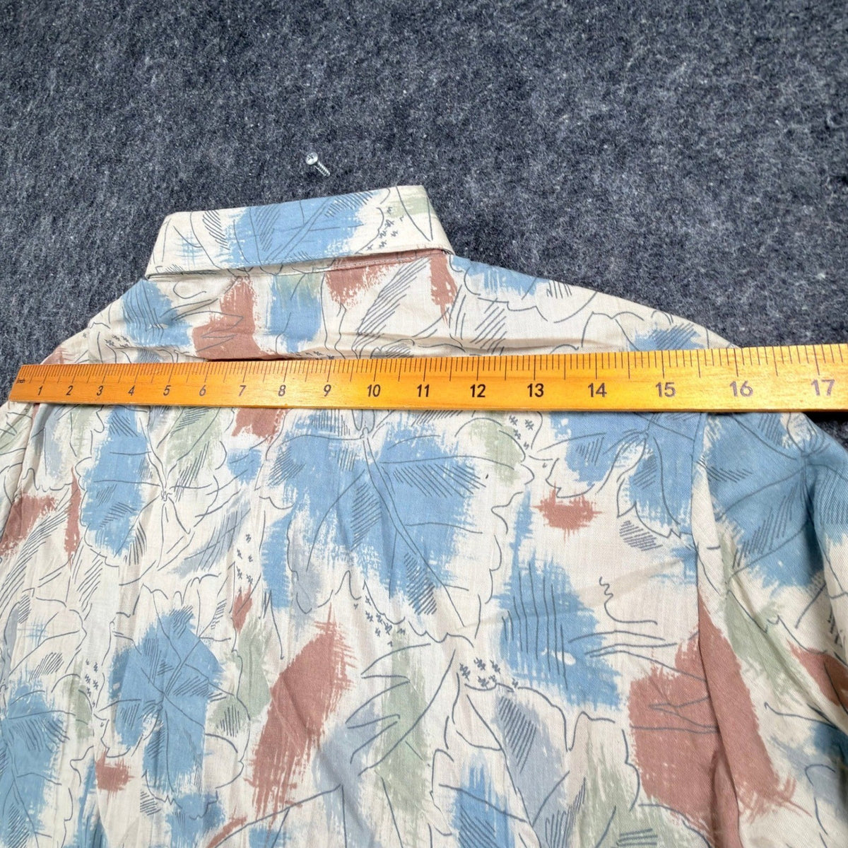 Cream Miss B long-sleeve shirt with blue, rust and green leaf print, ruler across shoulders