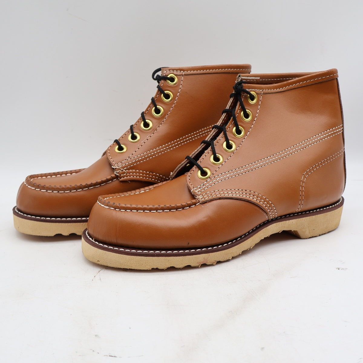 Three-quarter view of cognac-brown Cedar Crest moc-toe ankle boots with cream soles with toes pointing left