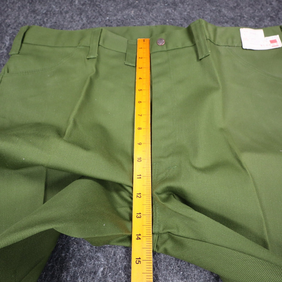 Ruler from the waistband to the crotch of green Aldens pants