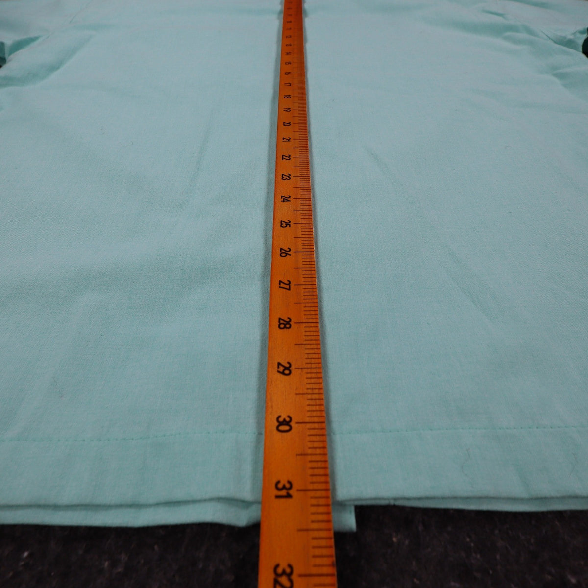Ruler along the back length of aqua blue Alexxus short-sleeve shirt