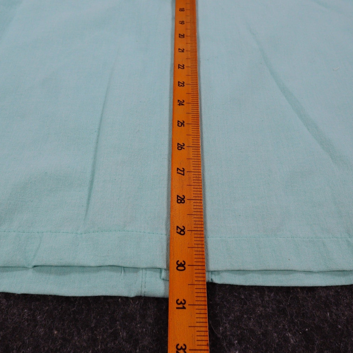 Ruler along the back length of aqua blue Alexxus short-sleeve shirt