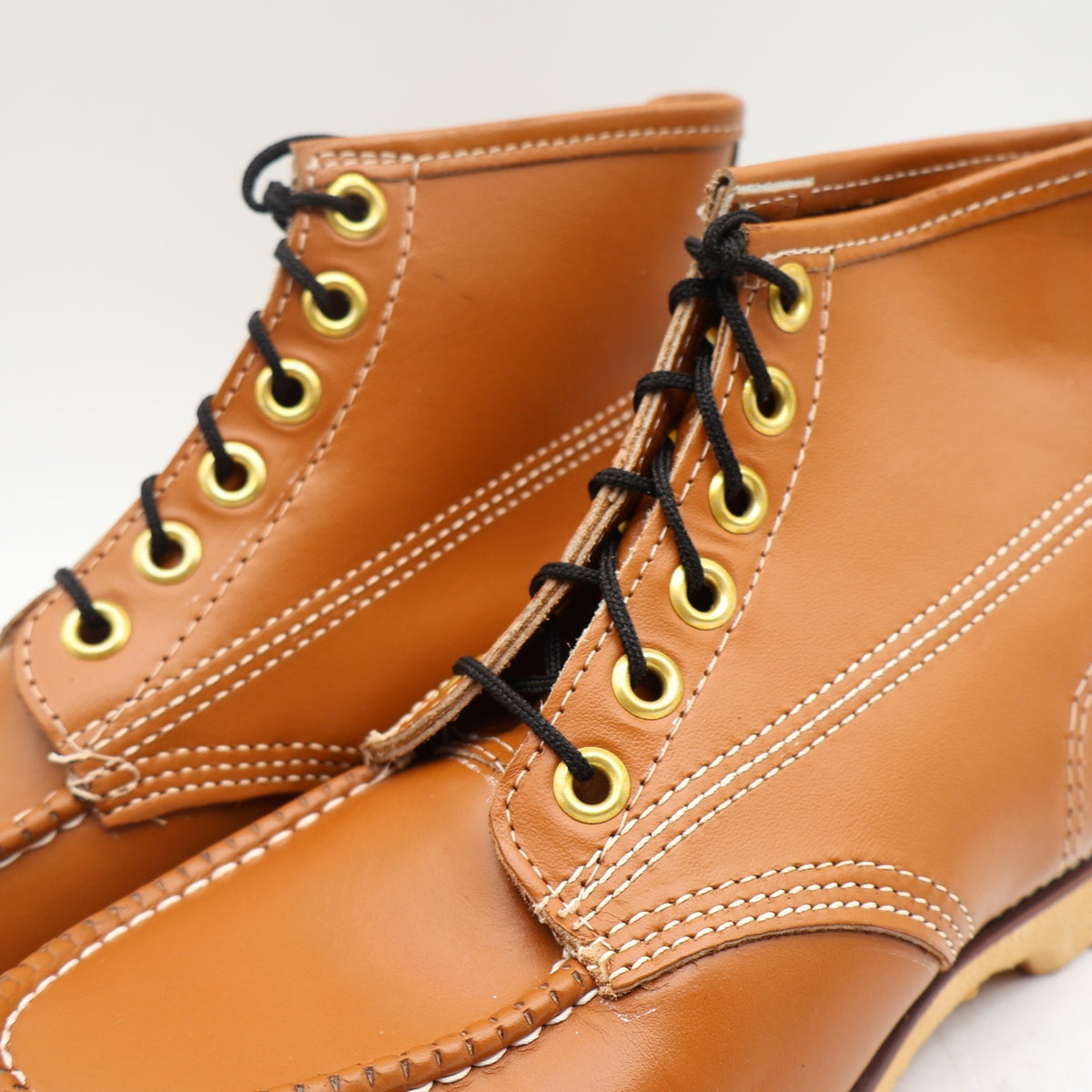 Close-up of black laces, gold-tone eyelets and cream stitching on Cedar Crest boots