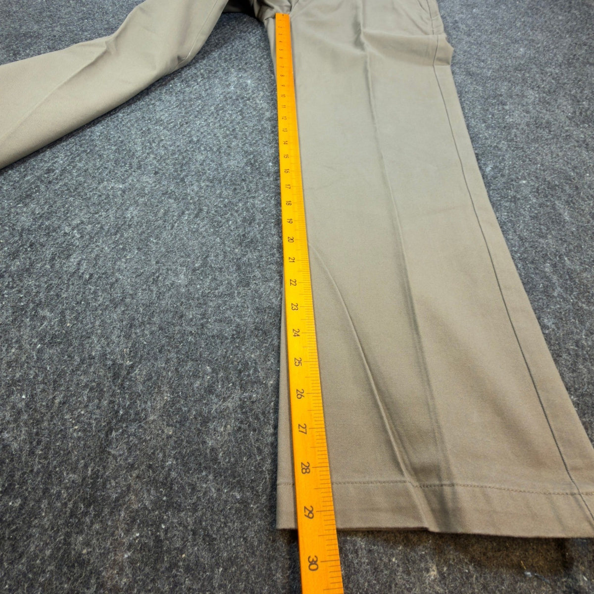 Ruler alongside the inner leg of olive Duck Head flat-front trousers