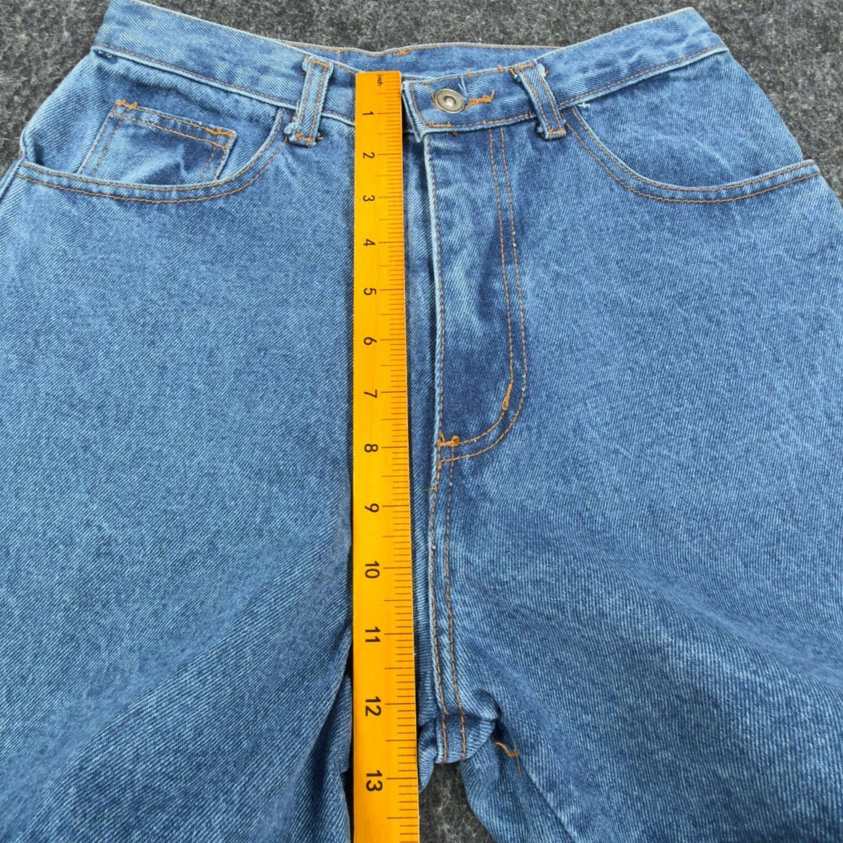 Ruler measuring the front rise of blue Boom Boom shorts