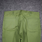 Close-up of the back waist and patch pockets of green Aldens pants