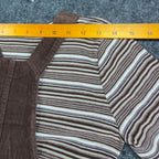 Ruler across the shoulders of the striped top in a brown Amy Too jumper dress set