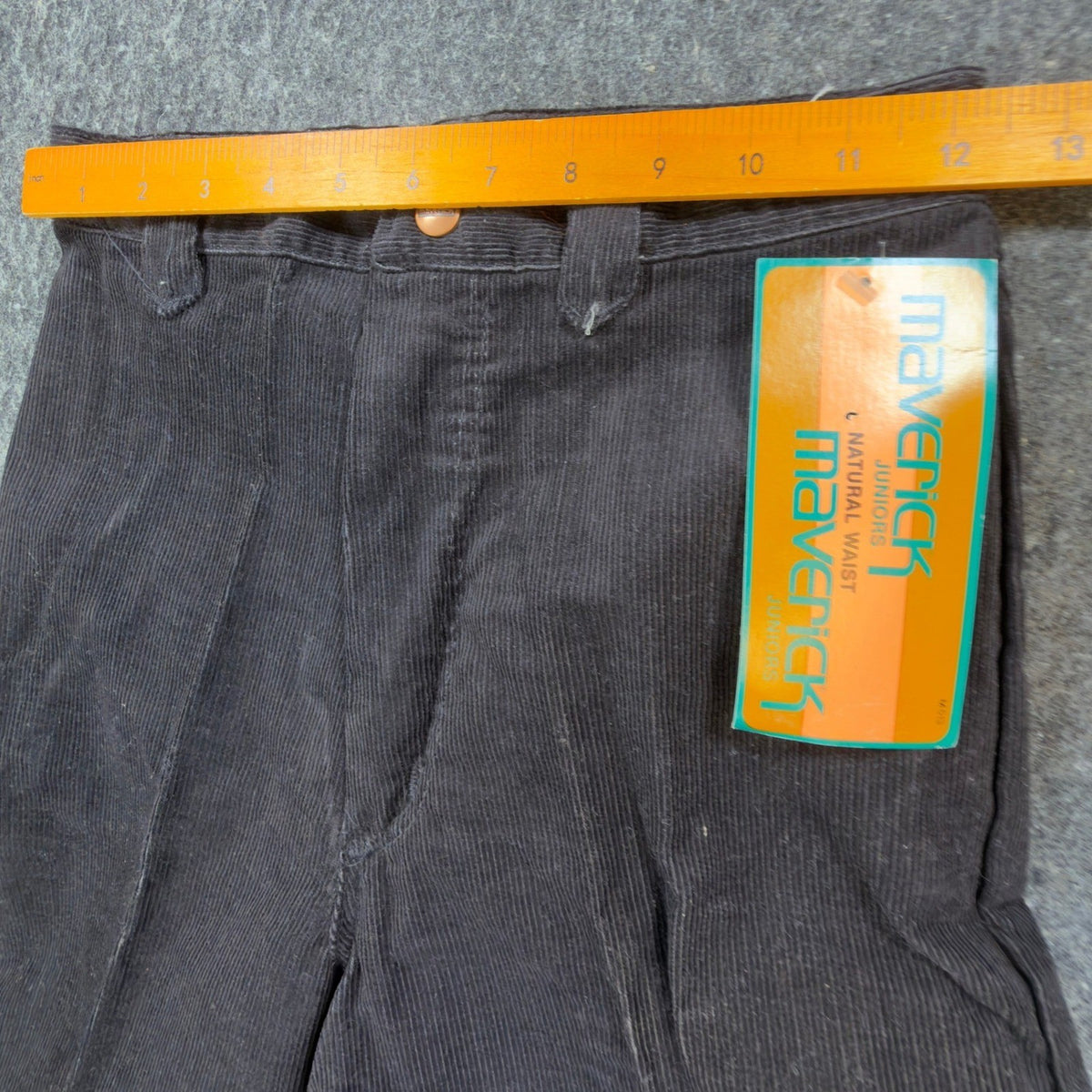 Black Maverick flared corduroy pants with embroidered back pockets, waist ruler view