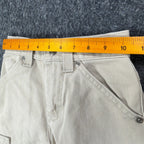 Ruler across the waistband of khaki Lee Pipes cargo shorts