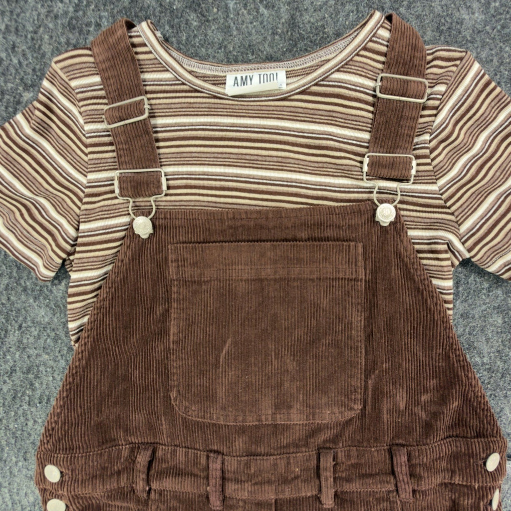 Close-up of the bib pocket, adjustable straps and striped top in a brown Amy Too jumper dress set
