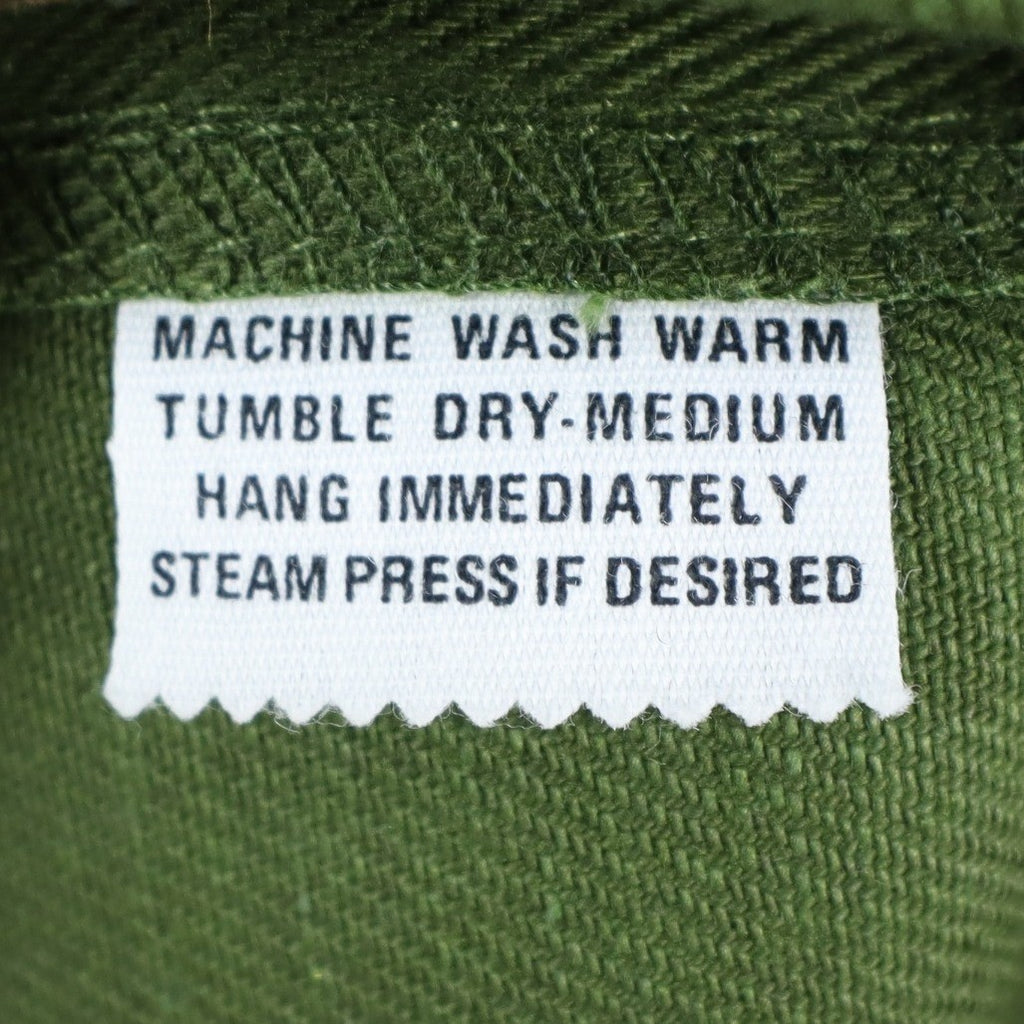 Close-up of the care-instruction label inside green Aldens pants