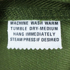 Close-up of the care-instruction label inside green Aldens pants