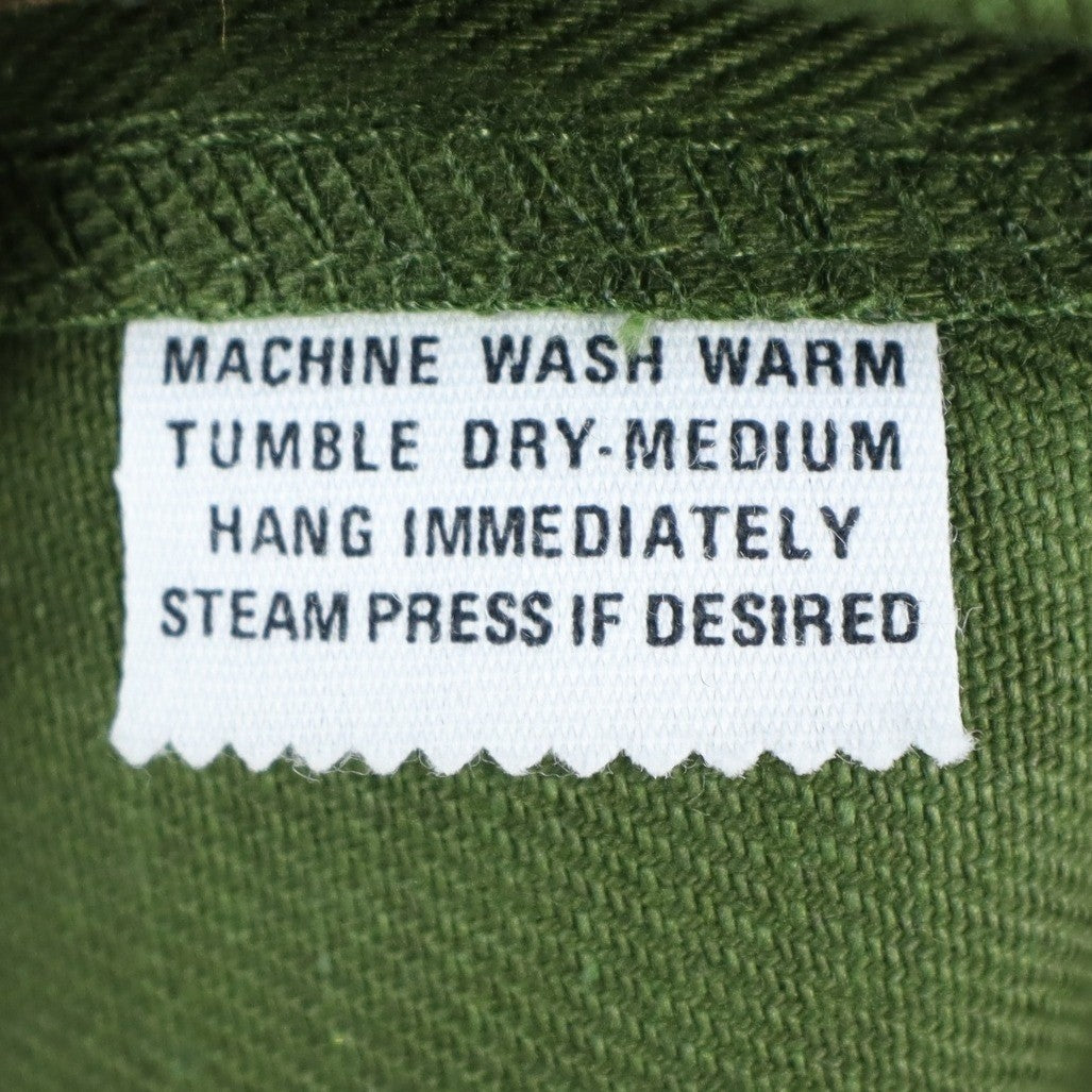 Close-up of the care-instruction label inside green Aldens pants