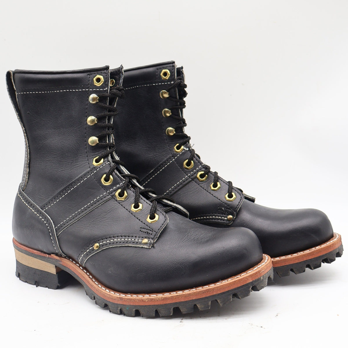 Black Carolina logger boots, angled front view with tan sole trim