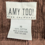 Close-up of the Amy Too brand, size and fabric-content labels inside a brown corduroy jumper dress