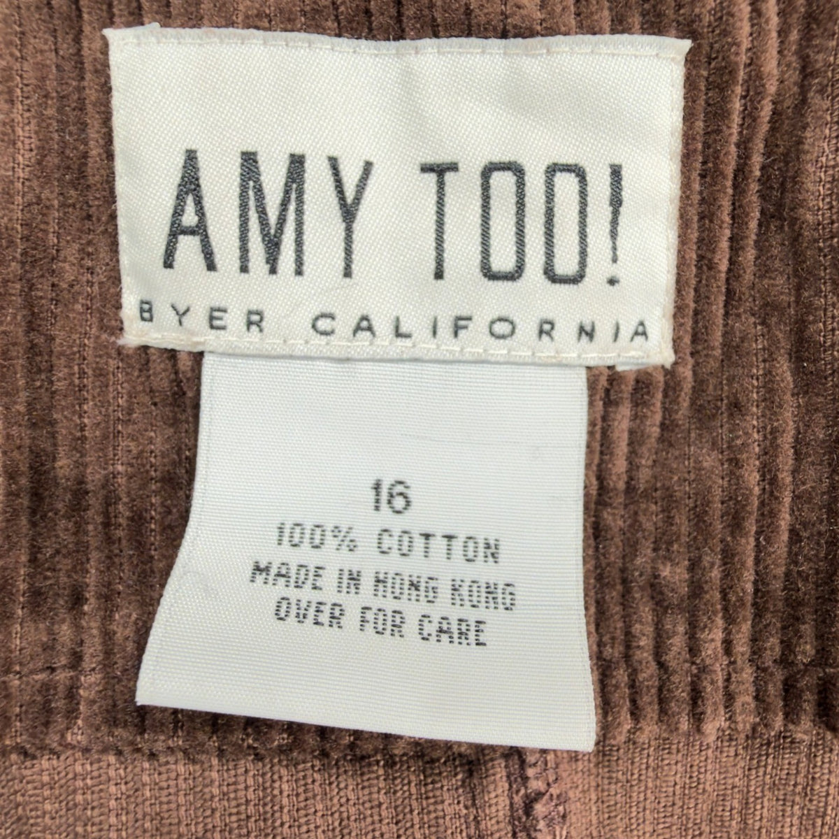 Close-up of the Amy Too brand, size and fabric-content labels inside a brown corduroy jumper dress