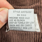 Close-up of the care-instruction label inside a brown Amy Too corduroy jumper dress