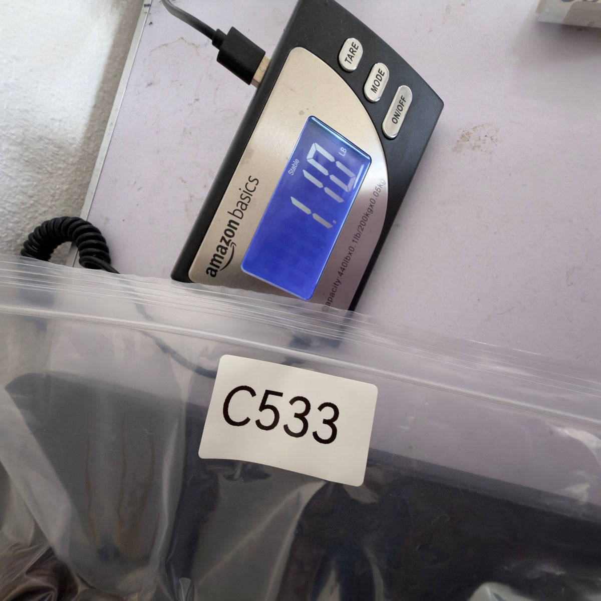 Inventory-labeled clear bag beside a digital scale