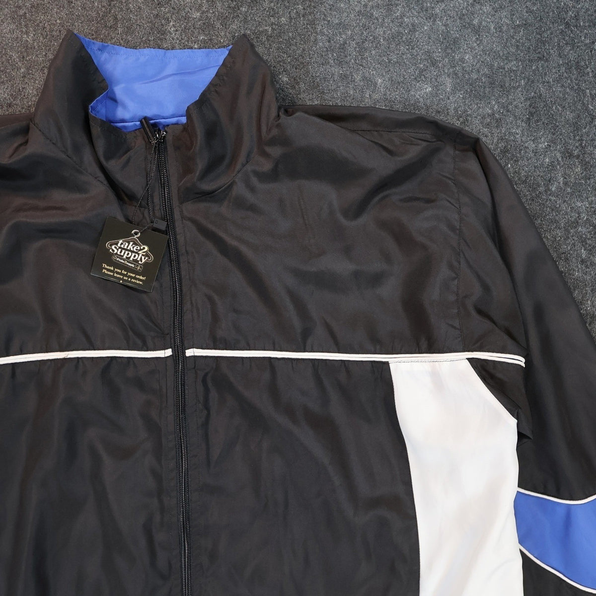 Close-up of the black stand collar, zipper and white chest piping