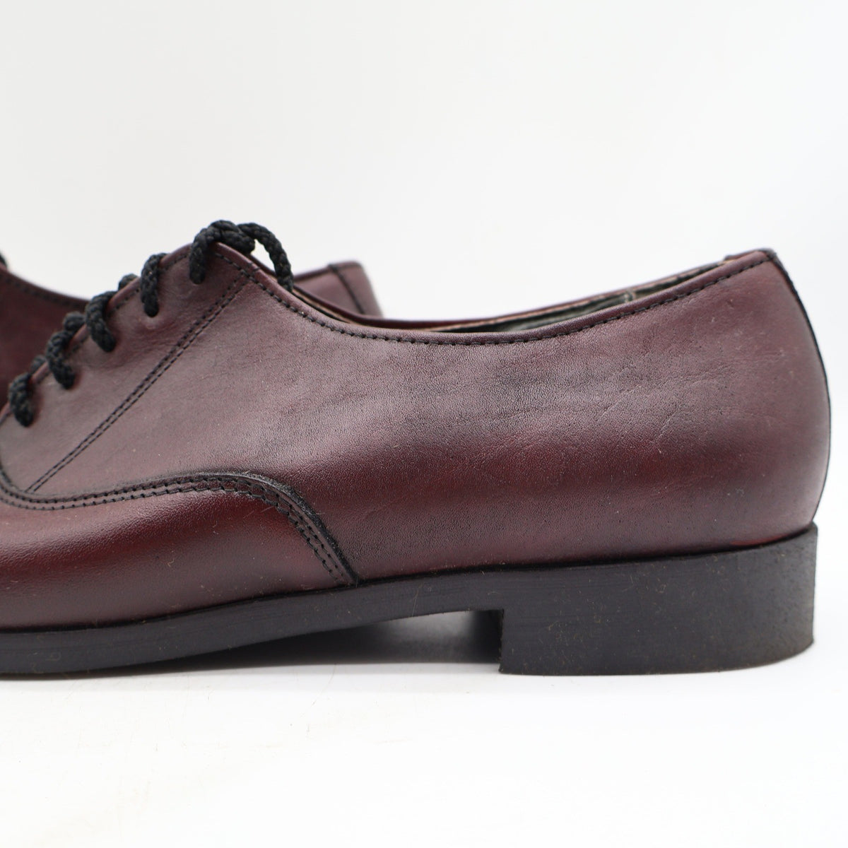 Close-up of a burgundy Armadillos shoe’s side seam and low black heel