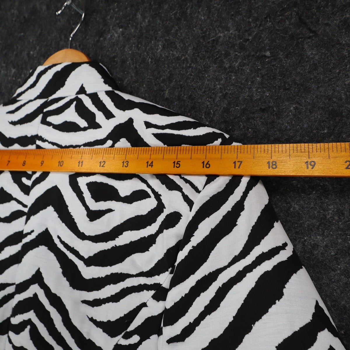 Ruler across the shoulders of black and white zebra-print Erin London blazer