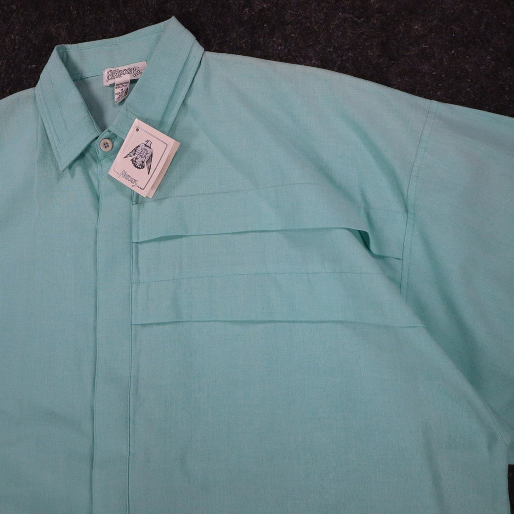 Angled close-up of the collar, front placket and chest pleats of an aqua blue Alexxus short-sleeve shirt