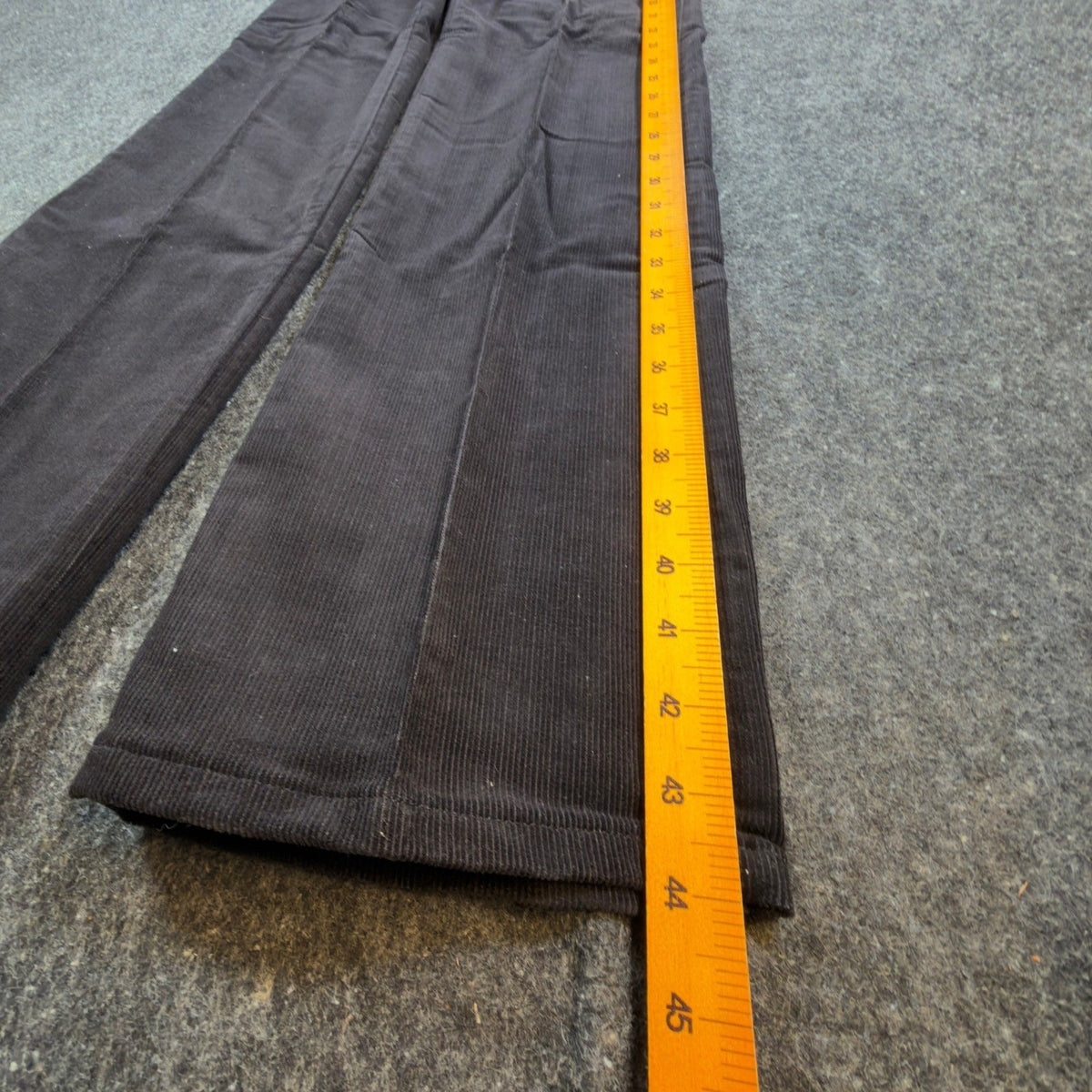 Black Maverick flared corduroy pants with embroidered back pockets, outer length ruler view
