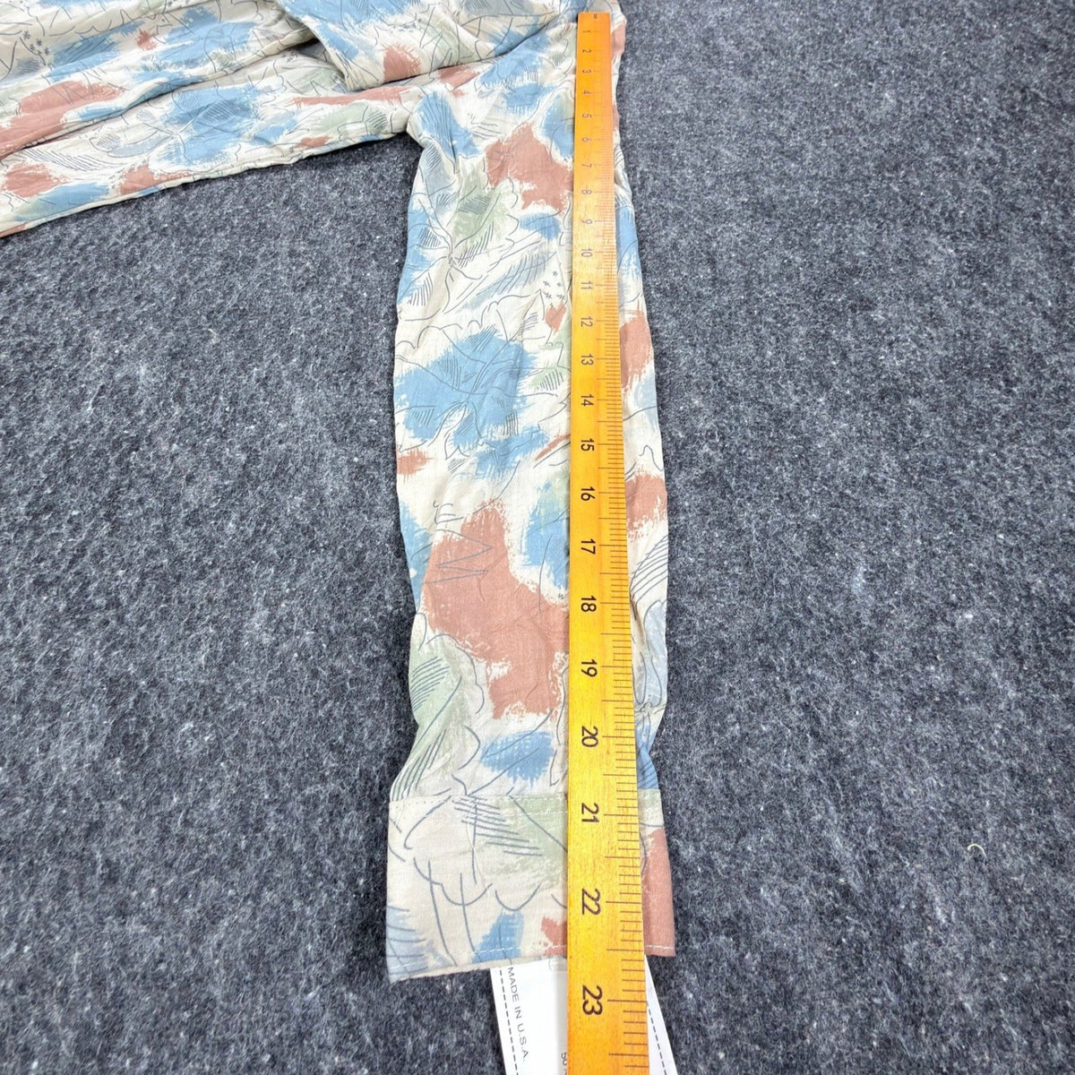 Cream Miss B long-sleeve shirt with blue, rust and green leaf print, ruler along sleeve to cuff