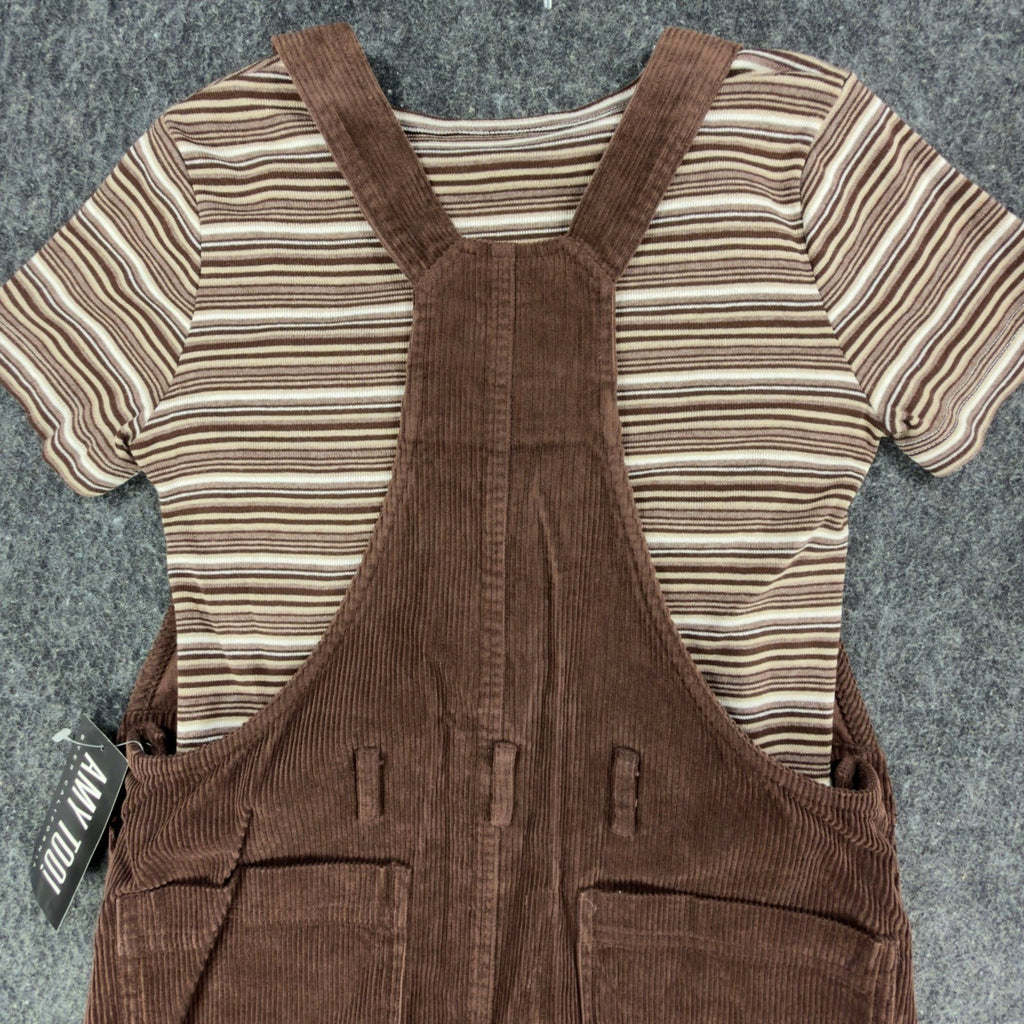 Close-up of the back straps and pockets of a brown Amy Too jumper dress over a striped top