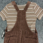 Close-up of the back straps and pockets of a brown Amy Too jumper dress over a striped top